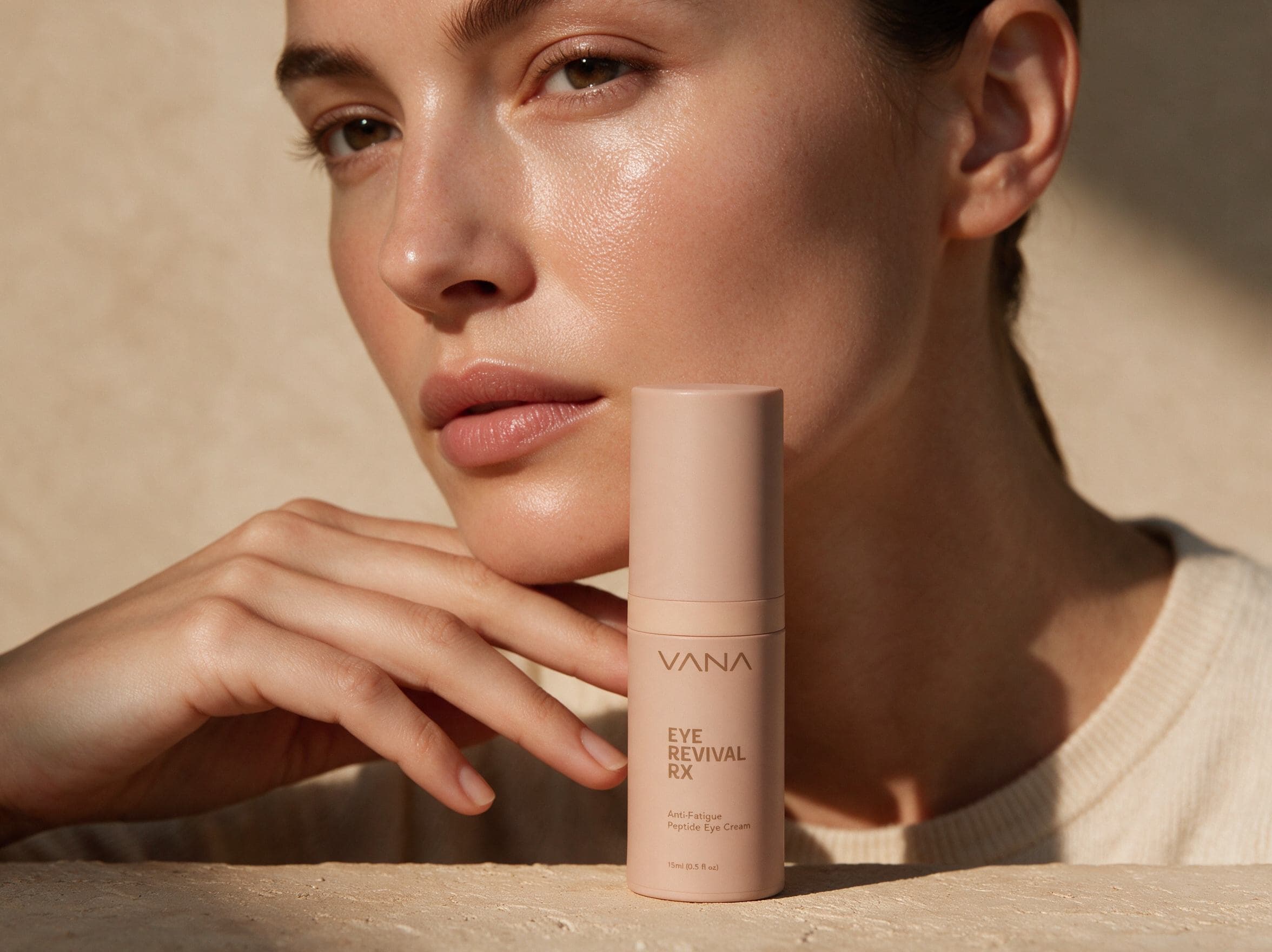 Model resting her chin on her hand beside the VANA Eye Revival RX bottle in golden light